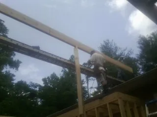 Carpenter setting a ridge beam over a new addition frame — Ice Dam Removal by Roofing Brothers in Lake Arrowhead