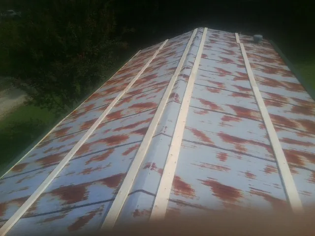 Rusted metal roof panels with new wood purlins before replacement — Storm Damage Roof Repair in Lake Arrowhead by Roofing Brothers